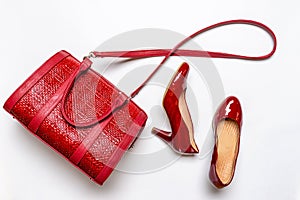 Beautiful set of handbag and shoes in red colors on white background. Spring fashionable outfit, casual stylish women`s clothes.