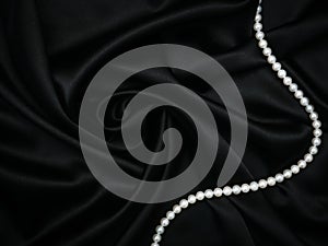 Beautiful set of womens evening accessories. Pearl neck and silk black dress. Elegant classic female jewel. Decoration design.