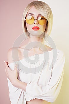 Sensual stylish woman in erotic white dress. Blue-eyed lady with perfect lips in modern colour sunglasses