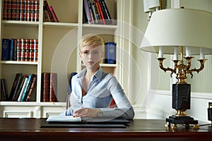 Beautiful sexy blonde woman in library parlor office read book meetings wear skinny skirt and blouse interior room classic style