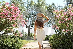 Beautiful sexy fashion woman enters in a garden between flowers in Sirmione on Lake Garda, Italy photo