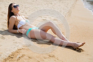 Beautiful girl lying on a sandy beach