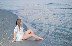 Beautiful girl in a white bathing suit and tunic