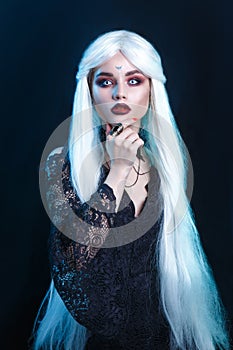 Beautiful sexy Halloween vampire woman portrait on dark magic background