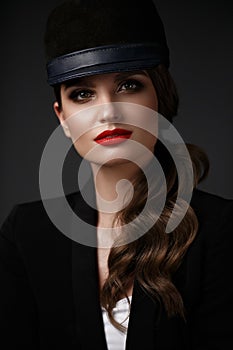 Beautiful sexy woman in a fashionable hat, with classic make-up, wave hair and red lips. Beauty face.