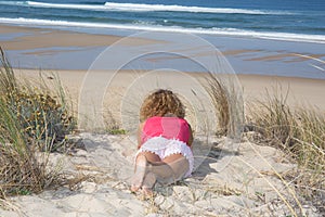 Beautiful woman lying on beach and looking to horizon over sea.