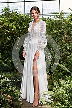 Beautiful sexy woman model bride wearing white long silk and lace wedding dress fashion espousal bright makeup brunette hairstyle photo
