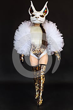 Beautiful sexy woman in rabbit bunny mask and carnival costume posing on dark background