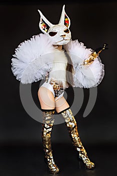 Beautiful sexy woman in rabbit bunny mask and carnival costume posing on dark background