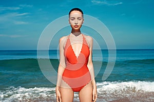 Beautiful sexy woman in red swimwear on the beach