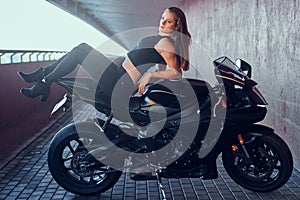 Beautiful sexy woman is relaxing on her motobike in quiet tunnel photo