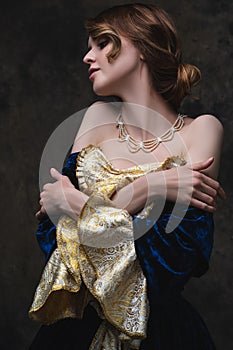 Beautiful sexy woman in renaissance dress on abstract dark background