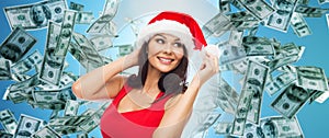 Beautiful woman in santa hat over money rain