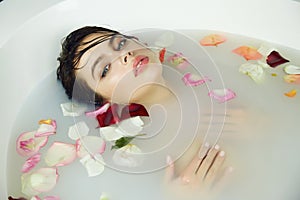 Beautiful woman takes bath rose candles Valentine's day spa