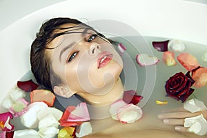 Beautiful woman takes bath rose candles Valentine's day spa