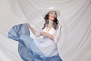 Beautiful sexy woman wear light blue multicolor dress summer collection silk casual style accessory hat tanned body brunette hair