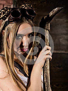 Beautiful worker with a pickaxe. Seductive and beautiful woman miner on a dark background