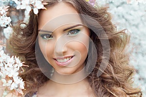 Beautiful young tender sweet smiling girl in a flowered garden with beautiful makeup