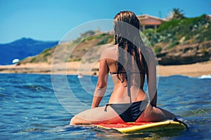 Beautiful young woman surfer girl waiting for a wave