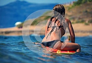 Beautiful young woman surfer girl waiting for a wave