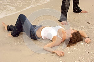 Beautiful young woman in wet jeans at beach photo