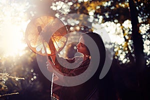 Beautiful shamanic girl playing on shaman frame drum in the nature