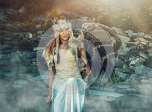 Beautiful shamanic woman with eagle in the nature.