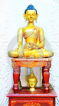 Beautiful shining classical Buddha Shakyamuni Siddhartha Gautama golden statue with open eyes  on the white
