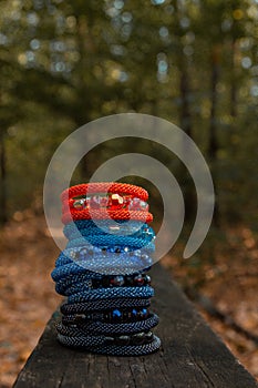 Beautiful, shiny, colorful bracelet set with large beadwork beads. On a wooden bench in the park. Jewelry on hand