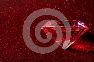 Beautiful shiny diamond on red glitter background. Space for text