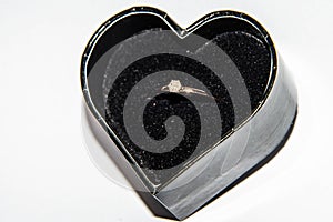Beautiful shiny engagement ring with diamond in heart shape velvet box  on white background Valentine`s Day