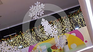 Beautiful shiny snowflake decorations hanging in a shopping center for the winter holidays. New Year decoration. Slow