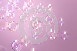 Beautiful shiny transparent soap bubbles float on pink background. Abstract, Celebration, Natual fresh summer background.