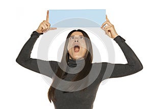 Beautiful shocked funny woman holding a blank blue billboard isolated on white background