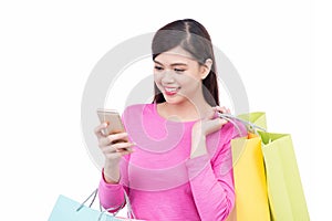 Beautiful shopping woman texting on her cell phone, isolated over white background