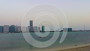 Beautiful shot of Abu Dhabi city skyline towers and beach at sunset - Kayaking at the beach