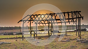 Beautiful shot of a bamboo cow shed with the sun during sunset time