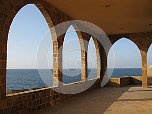 Beautiful shot of a big terrace with stone arches with a view of a seascape