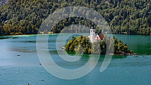 Beautiful shot of Bled Island by Lake Bled surrounded by forest mountains