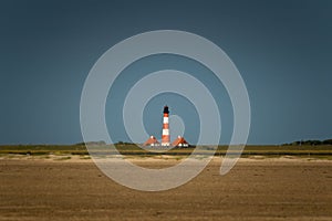 Beautiful shot of a blue sky over westerhever Lighthouse in a wide and empty landscape