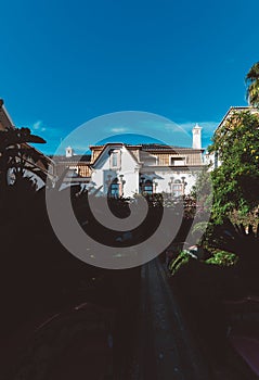 Beautiful shot of a building in Estoril, Portugal with a yard with different plants