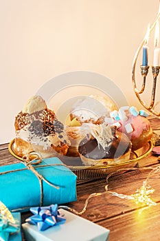 Beautiful shot of a burning Menorah lampstand next to pastry in celebration of Hanukkah