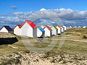 Beautiful shot of cabins with colorful roofs on the beach at Gouville-sur-Mer, Normandy, France