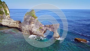 Beautiful shot from drone above rock formation on the sea flying over tropical paradise beach in the island of Bali in Indonesia