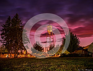 Beautiful shot of a farm in the countryside with a tall metal tower in the middle