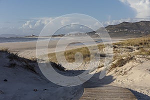 Beautiful shot of a footpath leading to Larino Beach in Galicia Spain photo