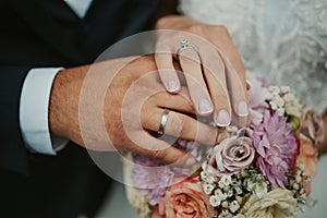Beautiful shot of the hands of a bride and groom showing their rings - wedding, anniversary