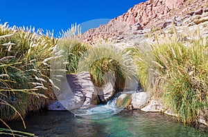 Beautiful shot of a hot spring surrounded by rocks in a desert San Pedro de Atacama, Chile