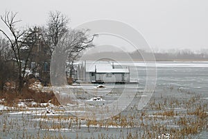 Beautiful shot of house boats moored on the pier of the frozen Mississippi River