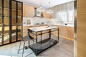 Beautiful shot of the kitchen in a modern apartment with a table with bar chairs